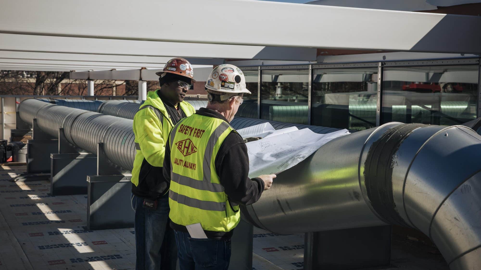 Contractor and worker in front of pipe